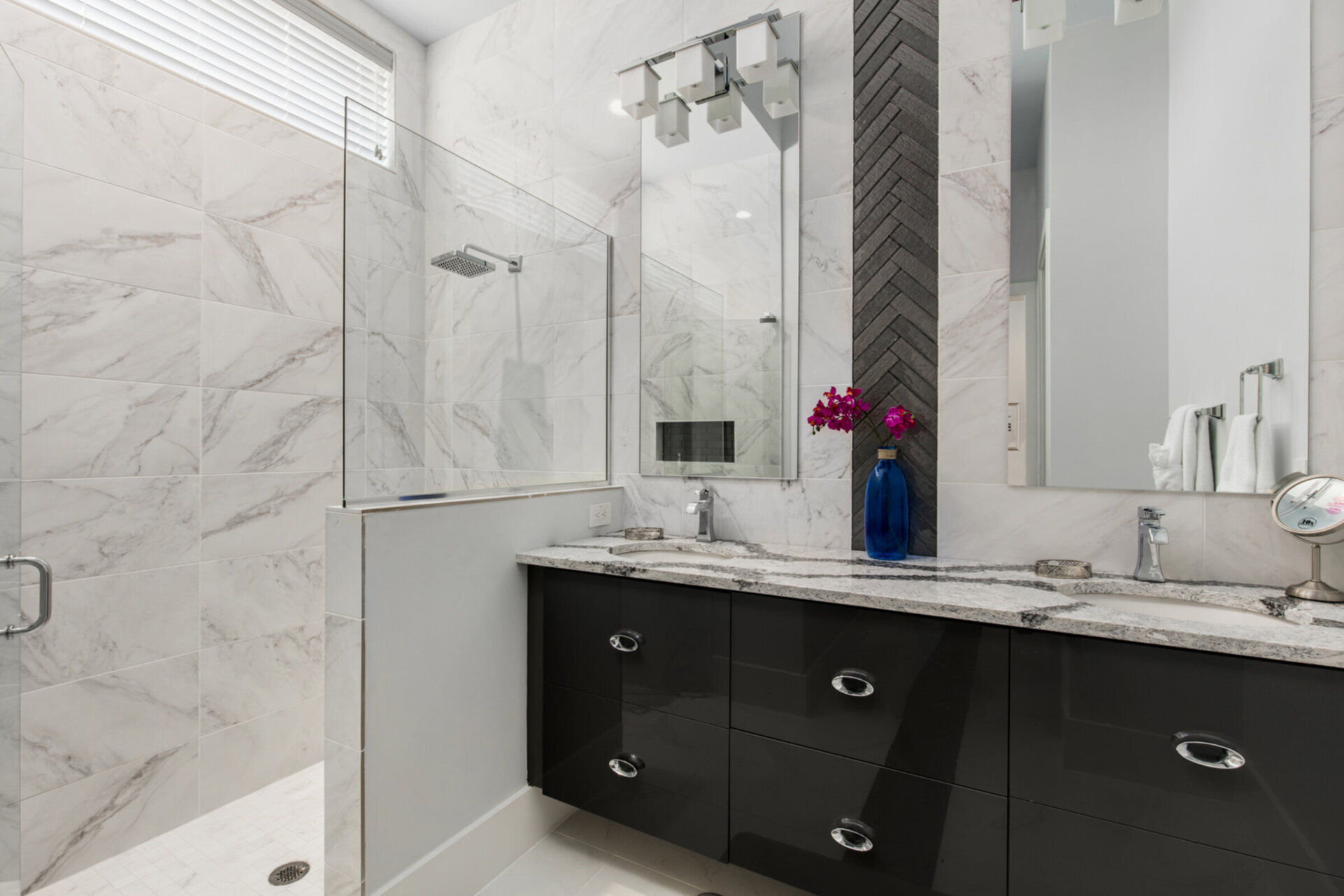 The ensuite bathroom has a large walk-in glass shower and double sinks