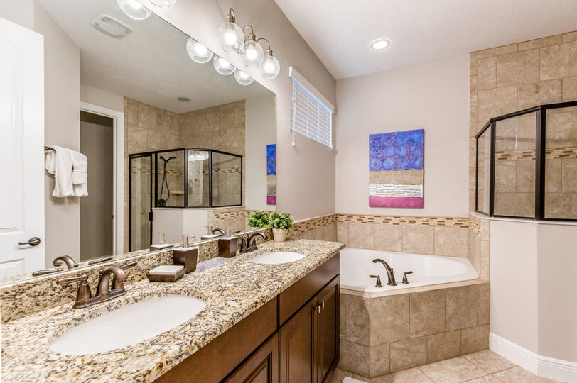 The master suite en-suite bathroom with dual vanity, garden tub, and walk-in shower