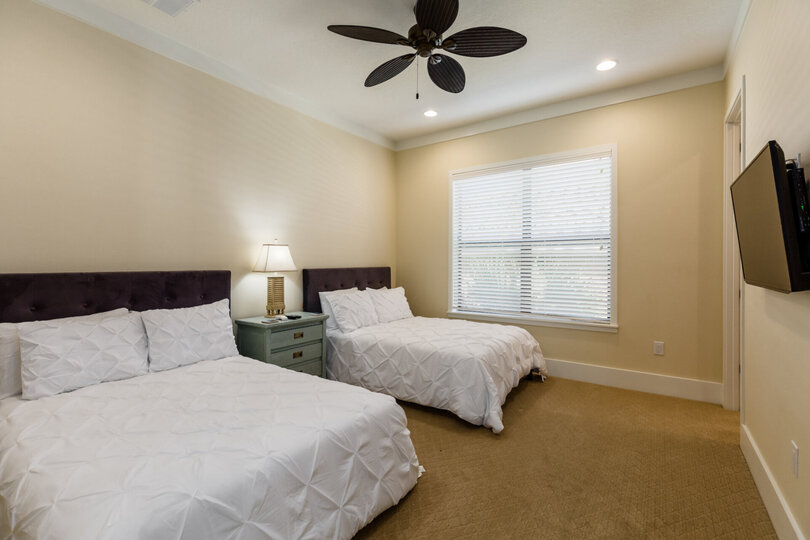 This bedroom has 2 full beds and a TV