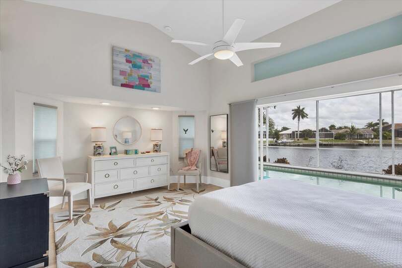 Primary bedroom with gorgeous water view, queen bed, attached bathroom and lanai access