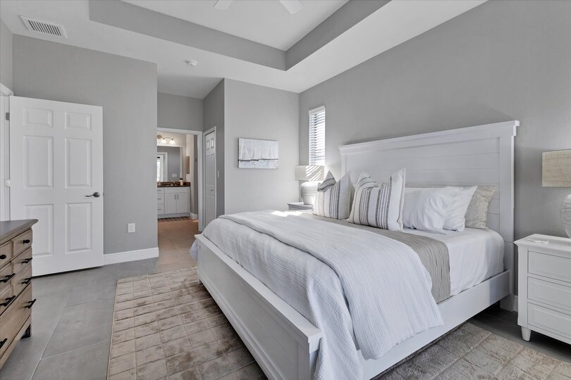 Primary bedroom with attached bathroom, lanai access, king bed and 43" Smart TV