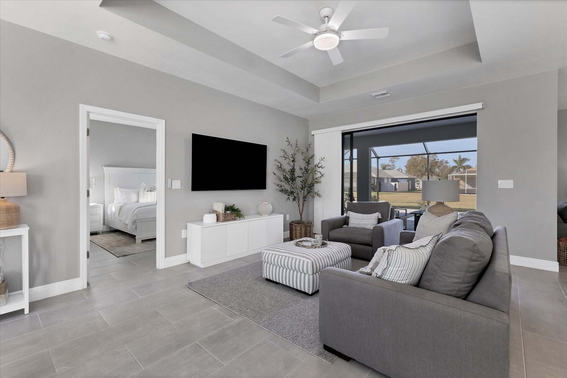 Living room overlooks the pool and features comfy seating and a 55" Smart TV