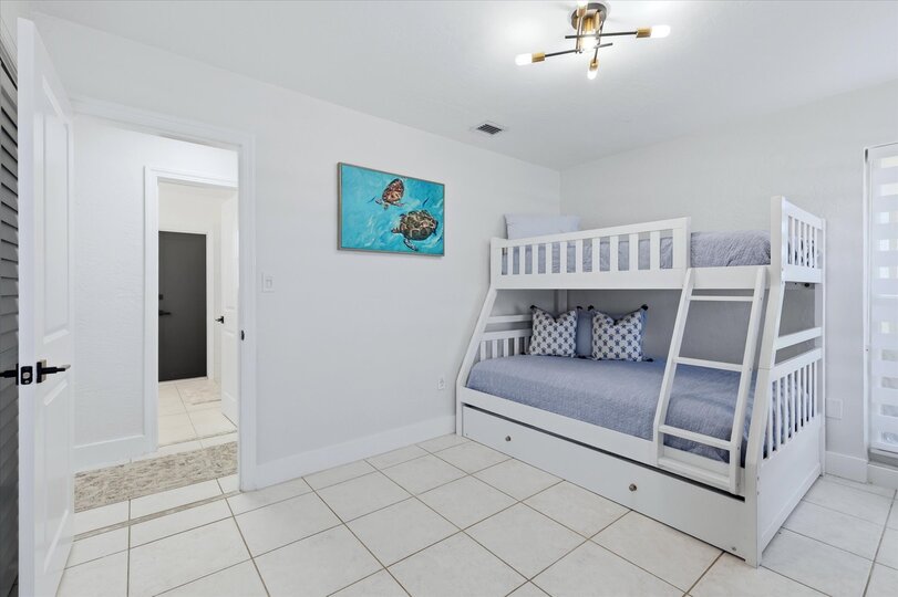 Guest bedroom with twin over double bunkbed with twin trundle, and 55-inch Smart TV