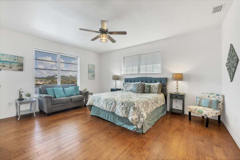 Upstairs primary suite with balcony access, king bed bed and attached bathroom