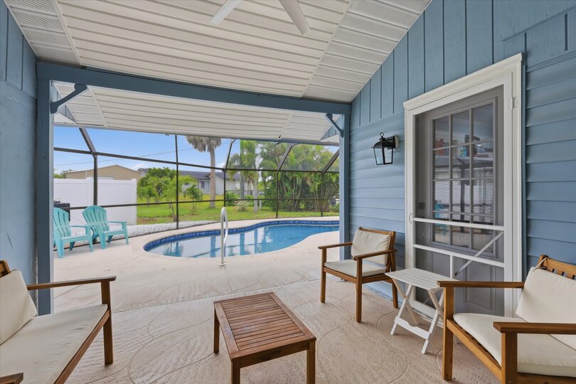 Outdoor living space overlooking sparkling pool. Also features outdoor shower, 2 sun loungers, 55-inch Smart TV, and a propane/pellet BBQ grill. Pool Size 25' x 12' x 5.5'D